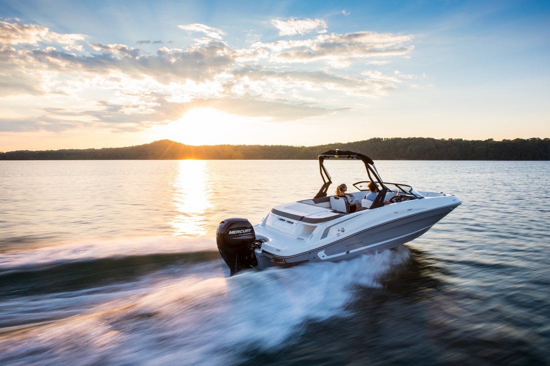 two people driving a boat as the sun rises